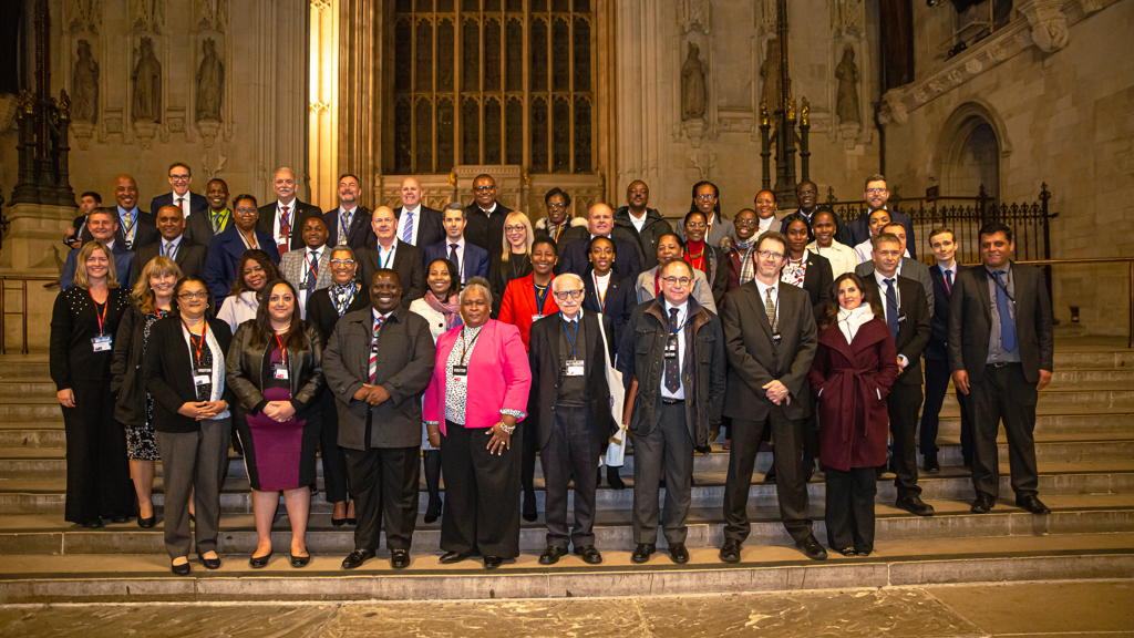 Delegates of the Overseas Territories Forum stand for a group photo in Westminster Hall, UK Parliament.